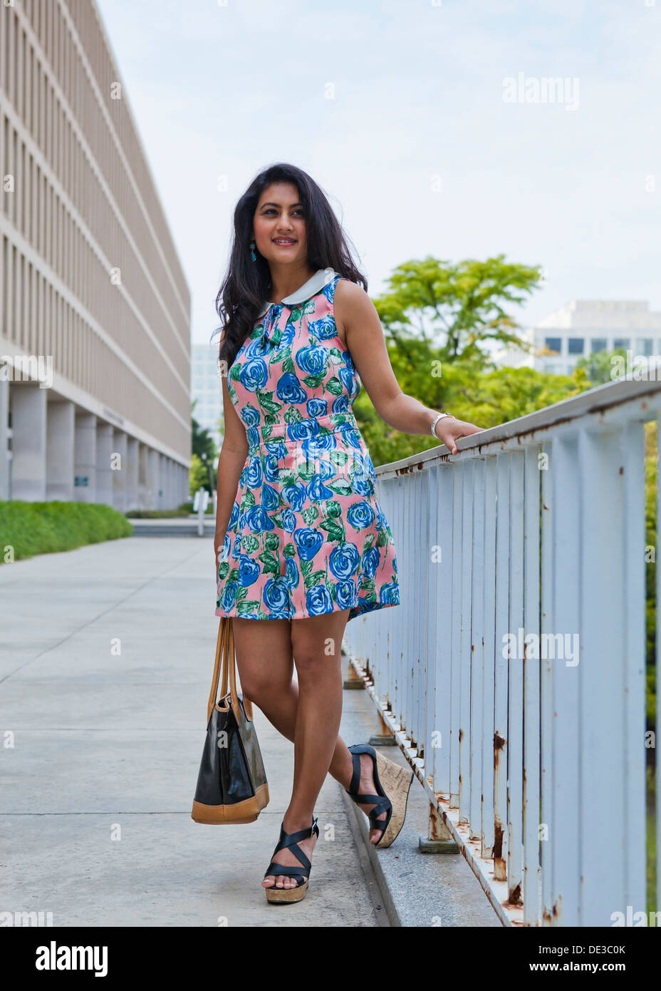 Jeune femme en environnement urbain portant une seule pièce motif floral dress Banque D'Images