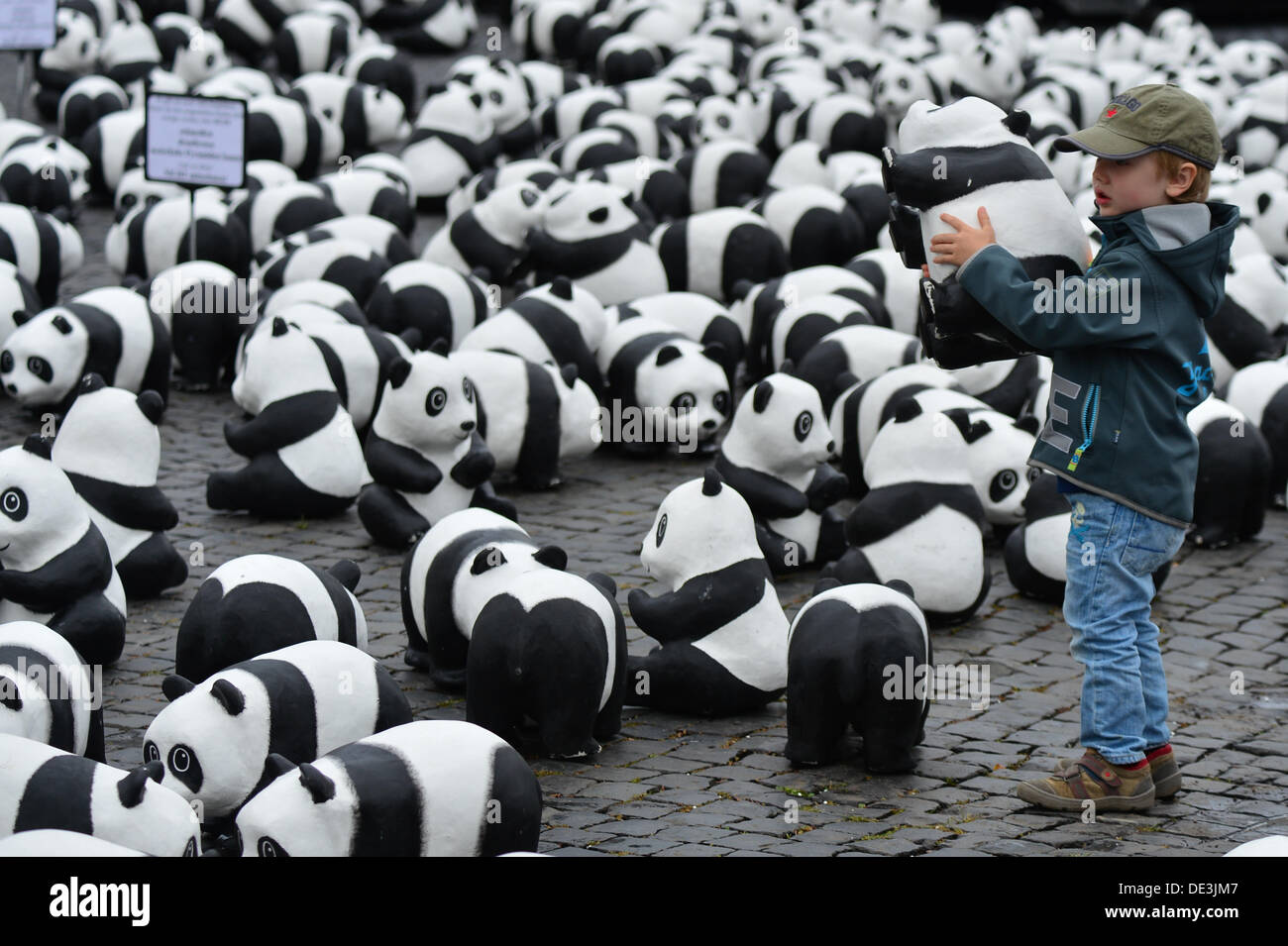 Erfurt, Allemagne. 11e Août, 2013. Quatre ans, Jonathan est titulaire d'un panda de ses sculptures en papier mâché à la place de la cathédrale d'Erfurt, Allemagne, 11 septembre 2013. À l'occasion du 50e anniversaire de l'organisme de conservation WWF Allemagne, un total de 1 600 pandas géants ont été placés sur la place de la cathédrale. Avec l'action, l'organisation environnementale WWF tient à souligner qu'il n'y a que 1 600 pandas laissé vivant à l'état sauvage. Photo : MARC NRIT/dpa/Alamy Live News Banque D'Images