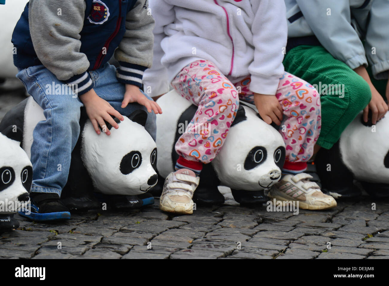 Erfurt, Allemagne. 11e Août, 2013. Les enfants s'asseoir sur un panda sculptures faites de papier mâché à la place de la cathédrale d'Erfurt, Allemagne, 11 septembre 2013. À l'occasion du 50e anniversaire de l'organisme de conservation WWF Allemagne, un total de 1 600 pandas géants ont été placés sur la place de la cathédrale. Avec l'action, l'organisation environnementale WWF tient à souligner qu'il n'y a que 1 600 pandas laissé vivant à l'état sauvage. Photo : MARC NRIT/dpa/Alamy Live News Banque D'Images