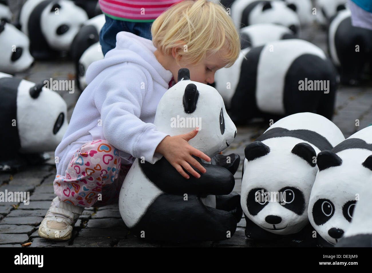 Erfurt, Allemagne. 11e Août, 2013. Trois ans, Yuna est titulaire d'un panda de ses sculptures en papier mâché à la place de la cathédrale d'Erfurt, Allemagne, 11 septembre 2013. À l'occasion du 50e anniversaire de l'organisme de conservation WWF Allemagne, un total de 1 600 pandas géants ont été placés sur la place de la cathédrale. Avec l'action, l'organisation environnementale WWF tient à souligner qu'il n'y a que 1 600 pandas laissé vivant à l'état sauvage. Photo : MARC NRIT/dpa/Alamy Live News Banque D'Images
