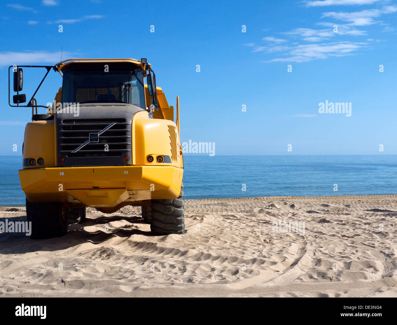 Vue de face d'un gros camion jaune pour le sable autour de la plage Banque D'Images