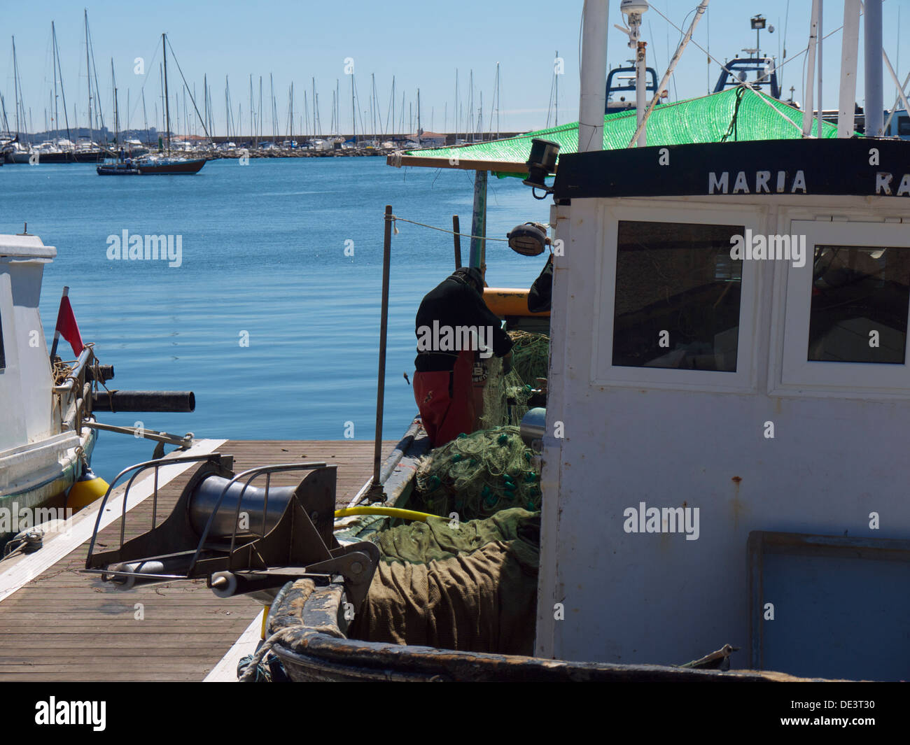 Pêcheur qui tend à ses filets à bord de son bateau de pêche Banque D'Images