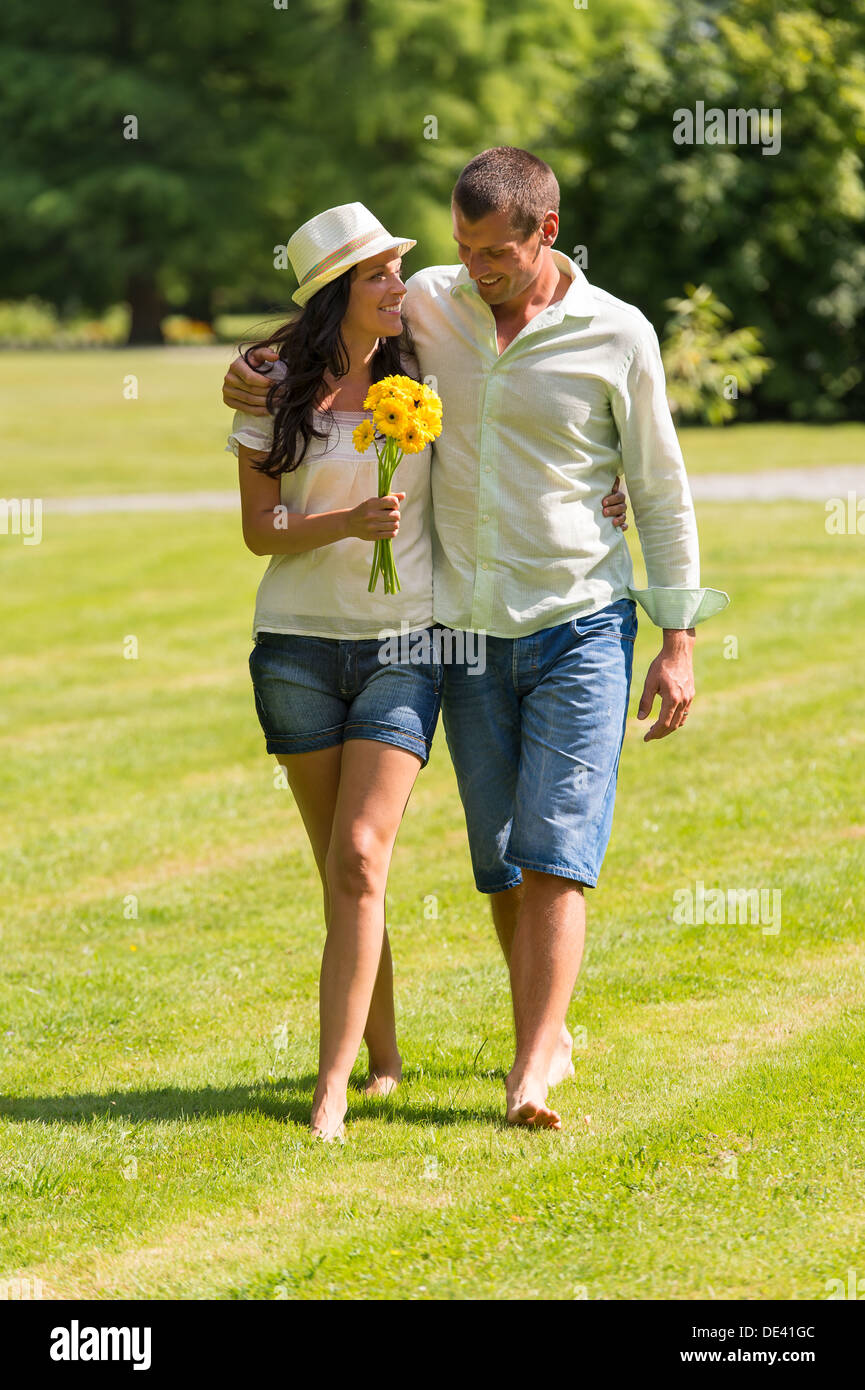 Happy young couple walking in park barefoot Banque D'Images