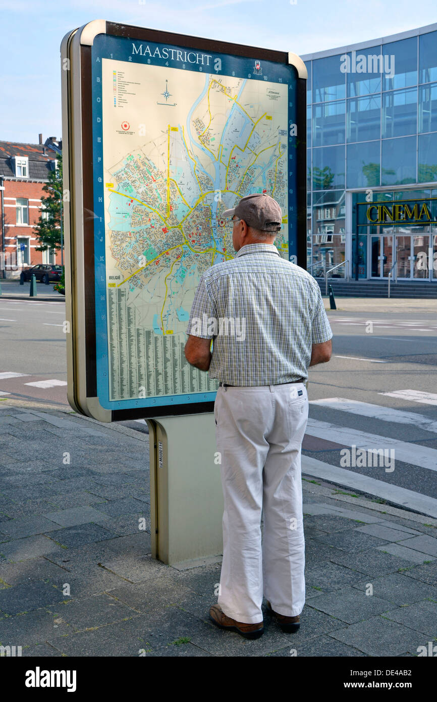 Maastricht carte de rue sur le panneau d'information routière vue arrière de visite modèle libéré touriste homme vérifiant l'emplacement Limbourg pays-Bas Europe UE Banque D'Images