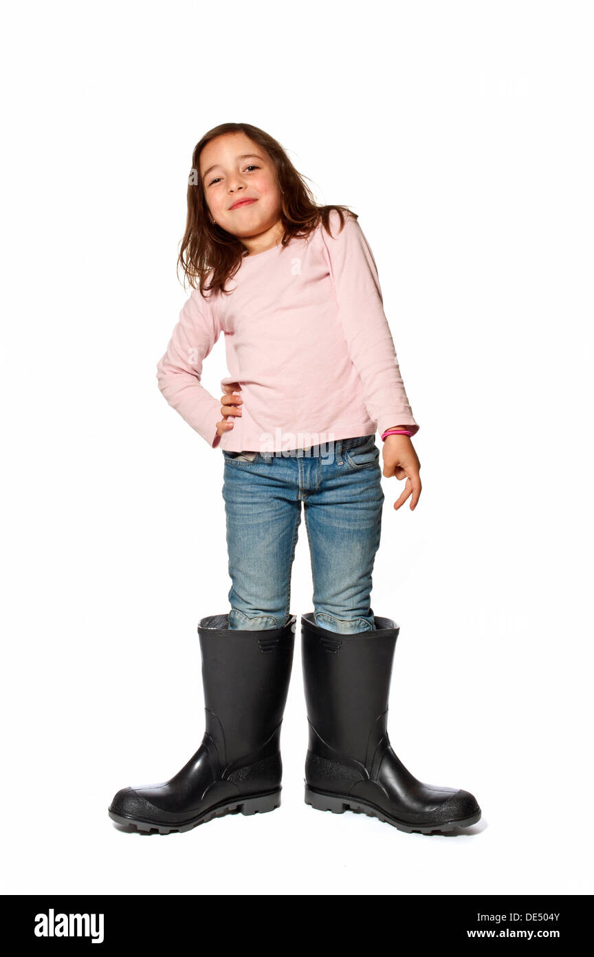 Petite fille de 7 ans portant des bottes qui sont bien trop gros Banque D'Images