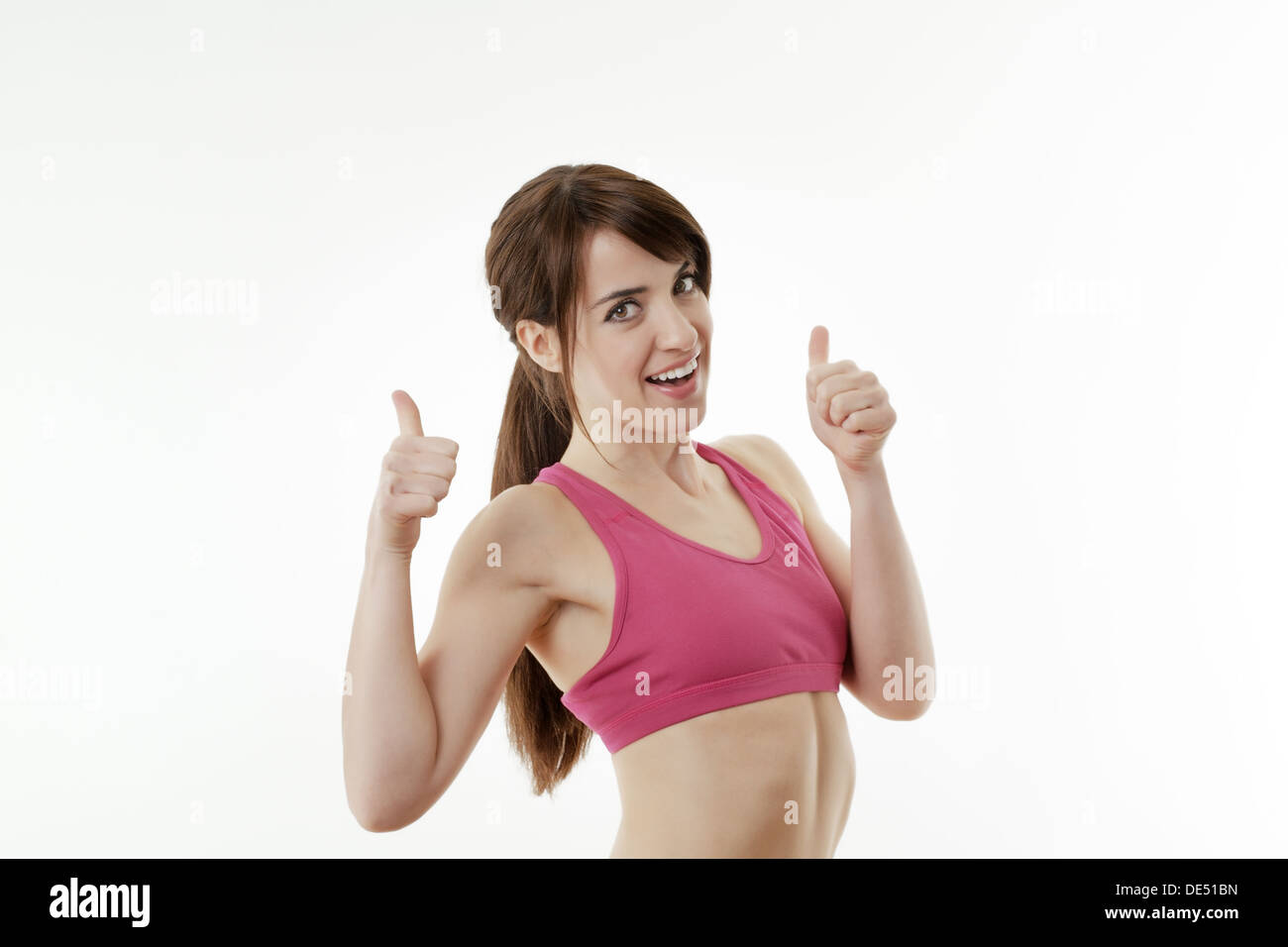 Happy woman with Thumbs up dans un soutien-gorge de sport à heureux Banque D'Images