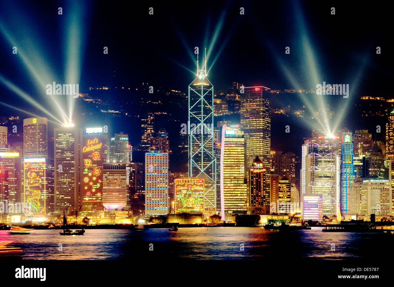 L'île de Hong Kong, Chine sur les toits de la ville de District Central de nuit avec éclairage laser spectacle vu à travers le port de Victoria à partir de Kowloon Banque D'Images