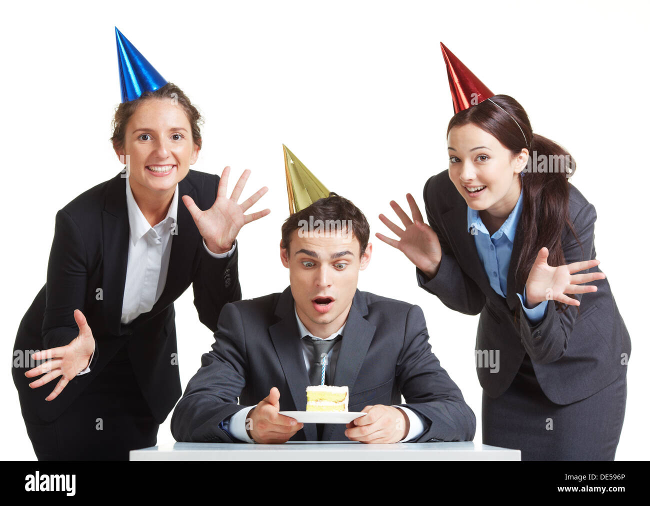 Portrait of young businessman in anniversaire cap à la recherche au morceau de gâteau avec deux femelles joyeuse près de par Banque D'Images