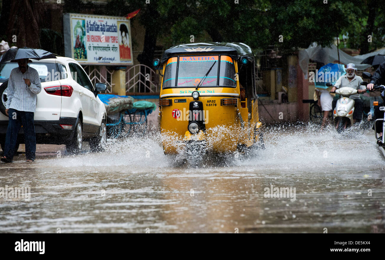 Auto rickshaws indiens de la conduite dans les rues humides à Puttaparthi, Andhra Pradesh, Inde Banque D'Images