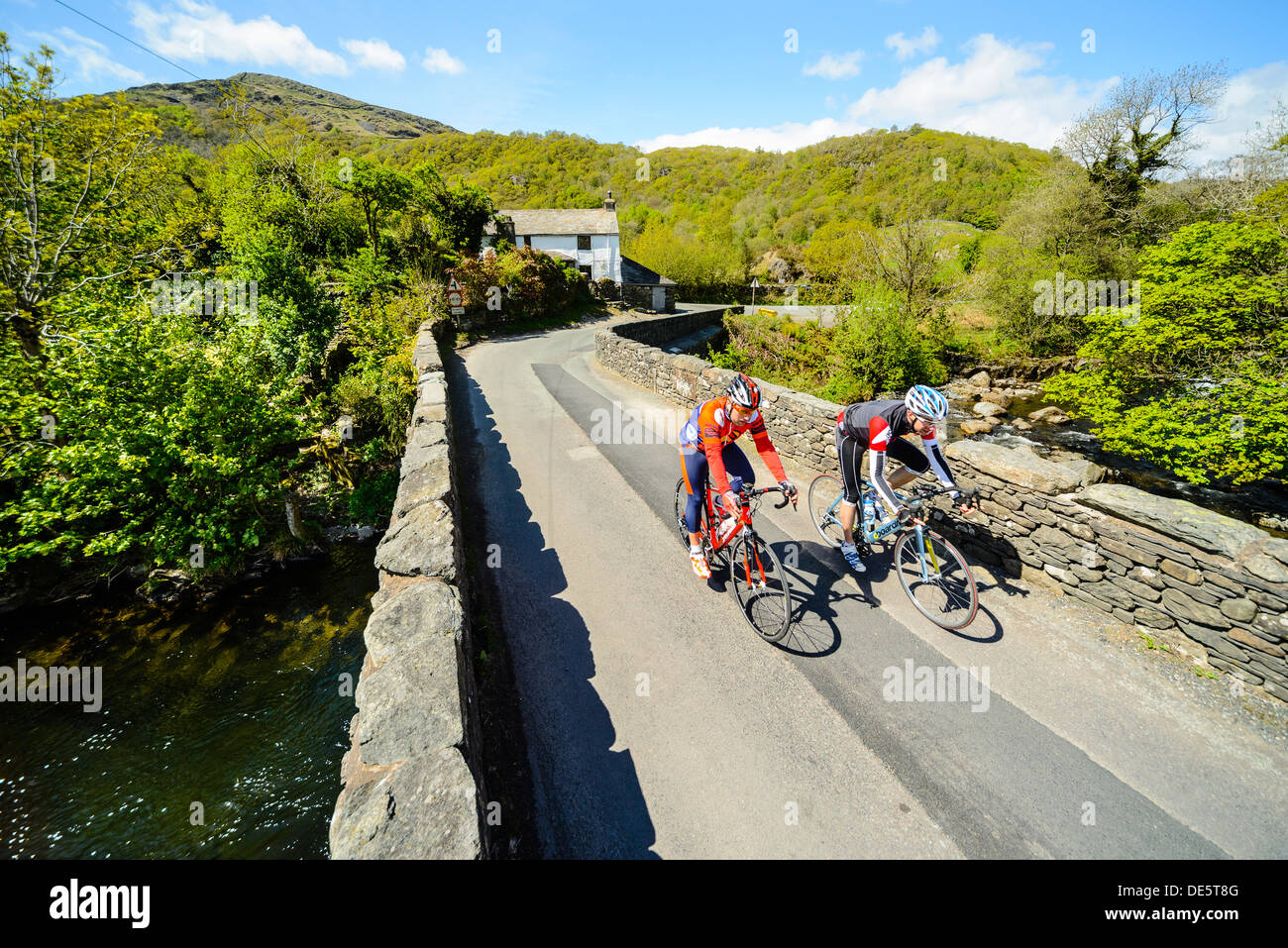 Les cyclistes sur Ulpha Bridge dans la vallée de Duddon dans le Lake District Banque D'Images