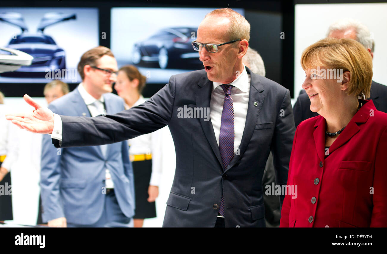 Francfort, Allemagne. 12e Août, 2013. La chancelière allemande, Angela Merkel (CDU, R) est accompagnée par le président du constructeur automobile Opel, Karl-Thomas Neumann, tels qu'ils se présentent à l'Opel stand lors de Merkel, tour à travers la 65ème Salon Automobile International Fankfurt (IAA) à Francfort, Allemagne, 12 septembre 2013. L'AAI est considéré parmi l'un des plus importants salons automobiles dans le monde entier et se déroule du 12 septembre au 22 septembre 2013. Photo : Daniel Reinhardt/dpa/Alamy Live News Banque D'Images