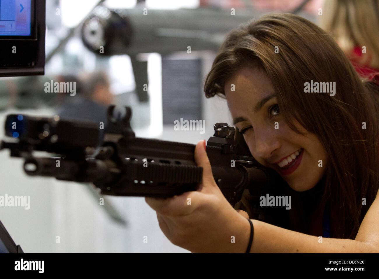 Londres, Royaume-Uni. Sept 12, 2013. Une femme essaie un fusil d'assaut à l'équipement de défense et de sécurité (DSEI) Foire aux armements à l'Excel Centre dans l'Est de Londres qui regroupe des fabricants d'armes de plus de cinquante pays à travers le monde : Crédit amer ghazzal/Alamy Live News Banque D'Images