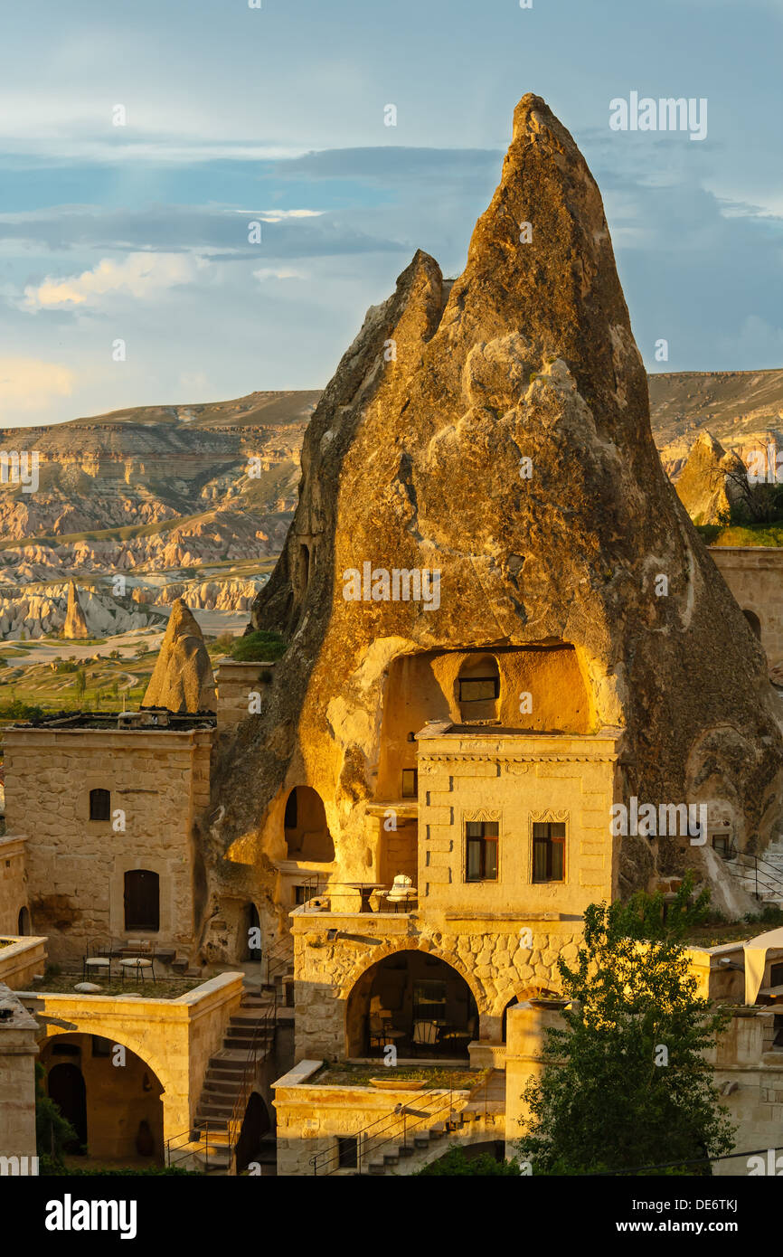 Chambres d'hôtel coupés dans la roche à la lumière du soleil couchant. Cappadoce, Turquie Banque D'Images