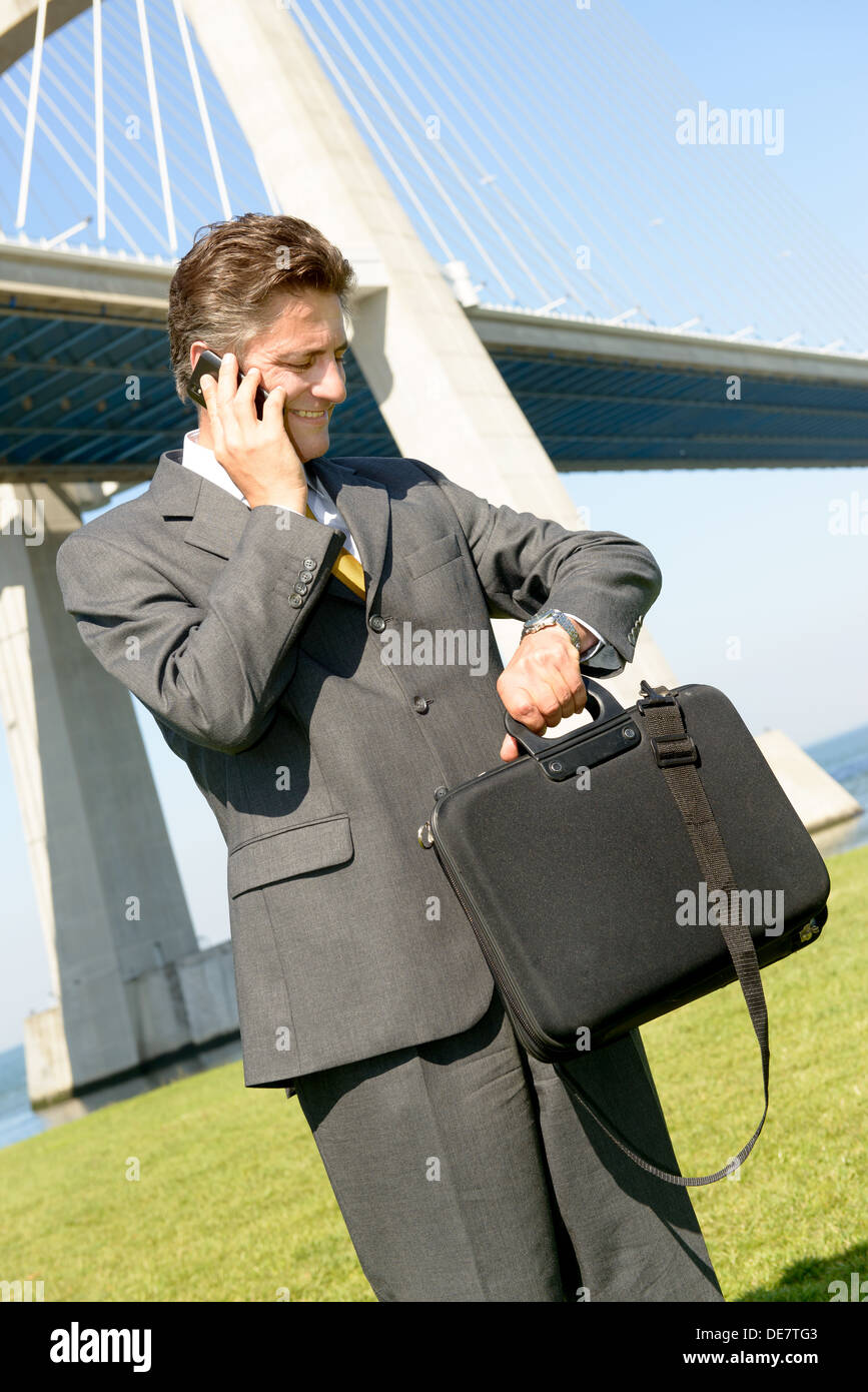 Businessman with cellphone outdoors Banque D'Images