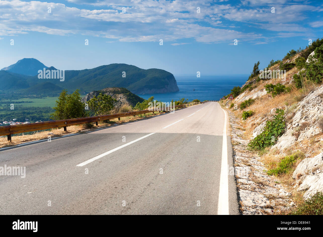 Route de montagne avec bleu ciel nuageux et de la mer sur un arrière-plan. La côte de la mer Adriatique, le Monténégro Banque D'Images