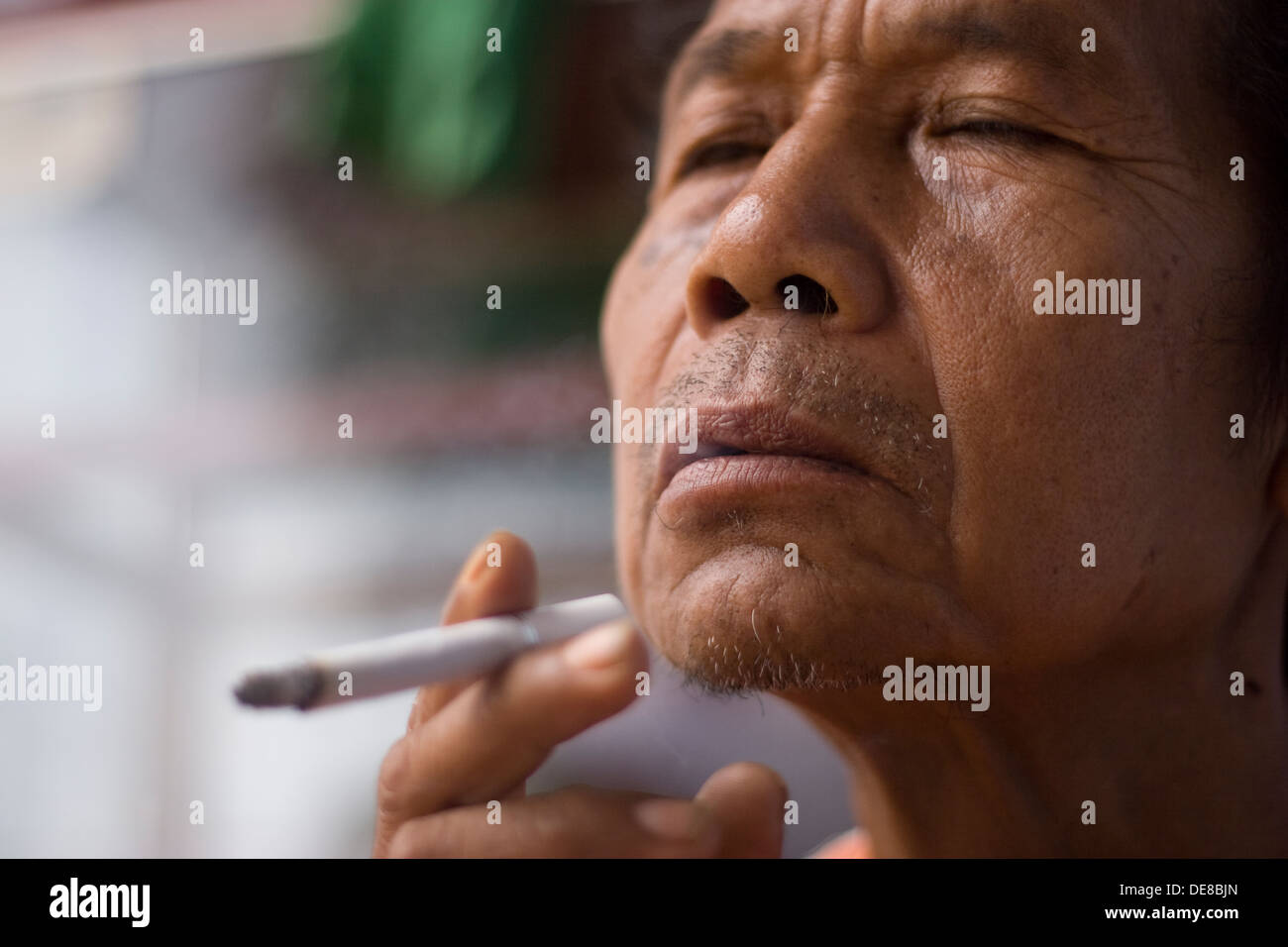 Le vieil homme, cigarette asiatique Banque D'Images
