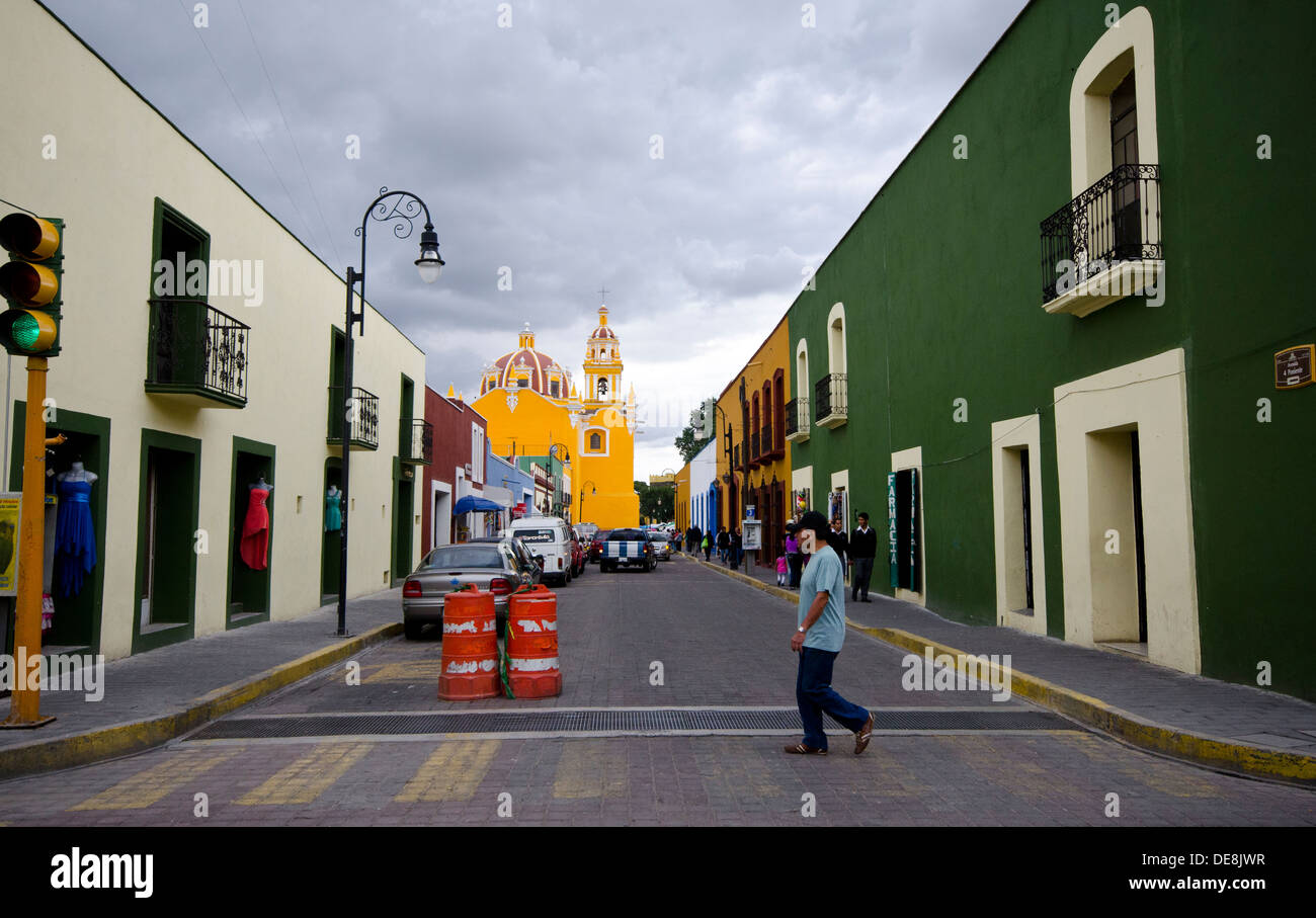 Homme marchant à travers crossing à Cholula au Mexique avec le jaune vif en arrière-plan Banque D'Images