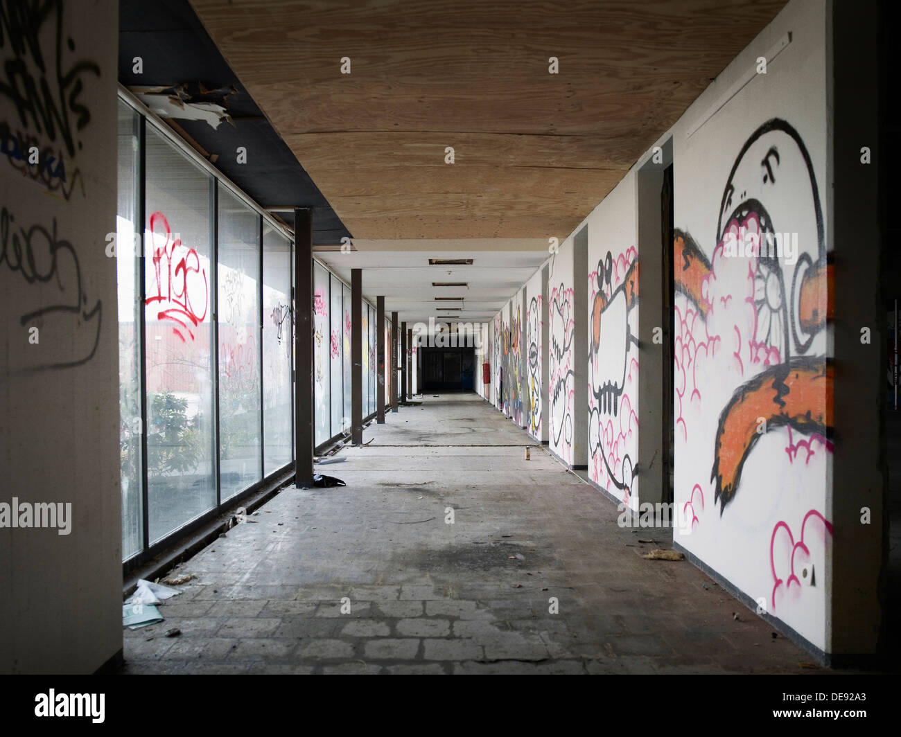 Couloir de l'immeuble abandonné avec des graffitis sur les murs et fenêtres Banque D'Images