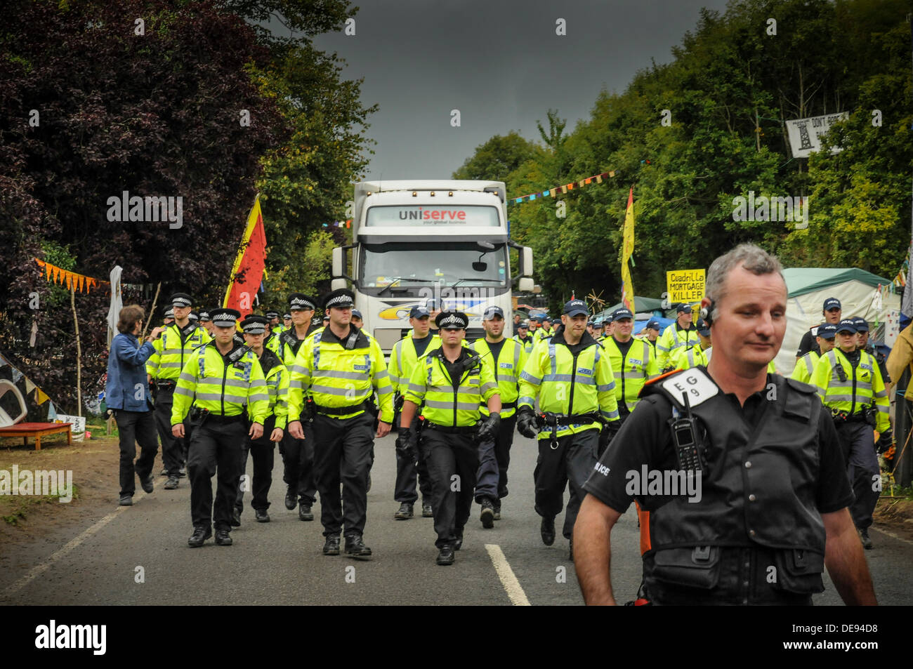Balcombe, West Sussex, UK . 13e Août, 2013. Des agents de police avaient à marcher plus rapidement aujourd'hui que les manifestants n'entravé la progression de leur escort un autre camion à Cuadrilla site.. La fracturation anti écologistes protestent contre les forages d'essai par Cuadrilla sur le site de West Sussex qui pourraient mener à la processus de fracturation controversée.avis d'expulsion sous réserve de la décision de la cour sur le lundi a été affiché au camp anti fracturation hydraulique. Crédit : David Burr/Alamy Live News Banque D'Images