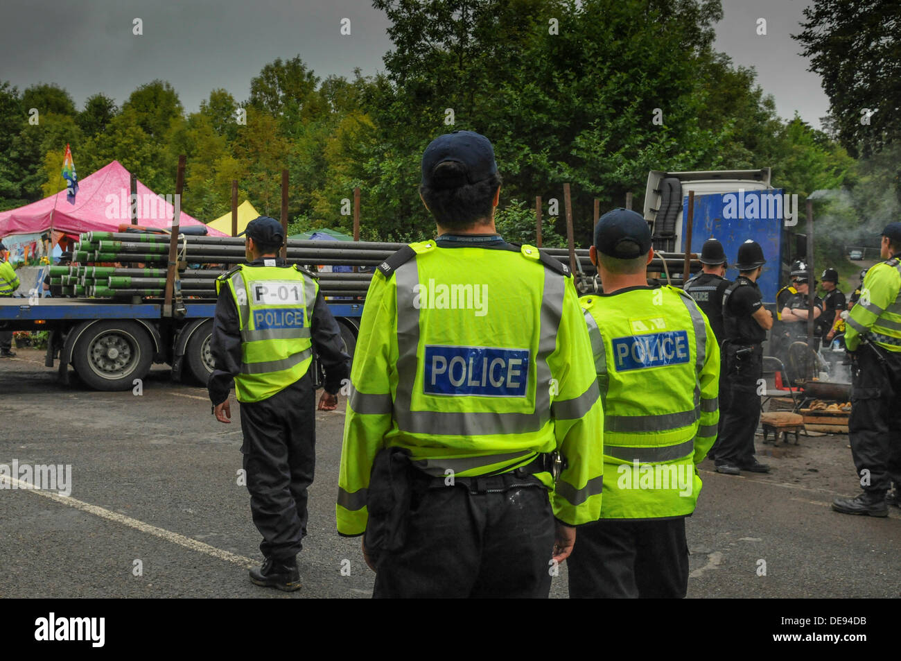 Balcombe, West Sussex, UK . 13e Août, 2013. Des agents de police avaient à marcher plus rapidement aujourd'hui que les manifestants n'entravé la progression de leur escort un autre camion chargé avec des tuyaux percés, Cuadrilla en entrée du site.. La fracturation anti écologistes protestent contre les forages d'essai par Cuadrilla sur le site de West Sussex qui pourraient mener à la processus de fracturation controversée.avis d'expulsion sous réserve de la décision de la cour sur le lundi a été affiché au camp anti fracturation hydraulique. Crédit : David Burr/Alamy Live News Banque D'Images