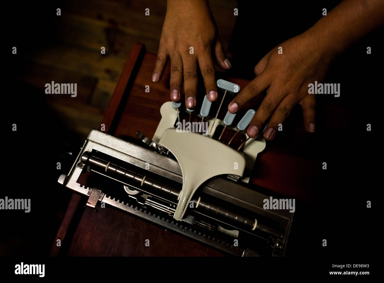 Un aveugle sur une machine à écrire braille types au club social pour les malvoyants à Lima, Pérou. Banque D'Images