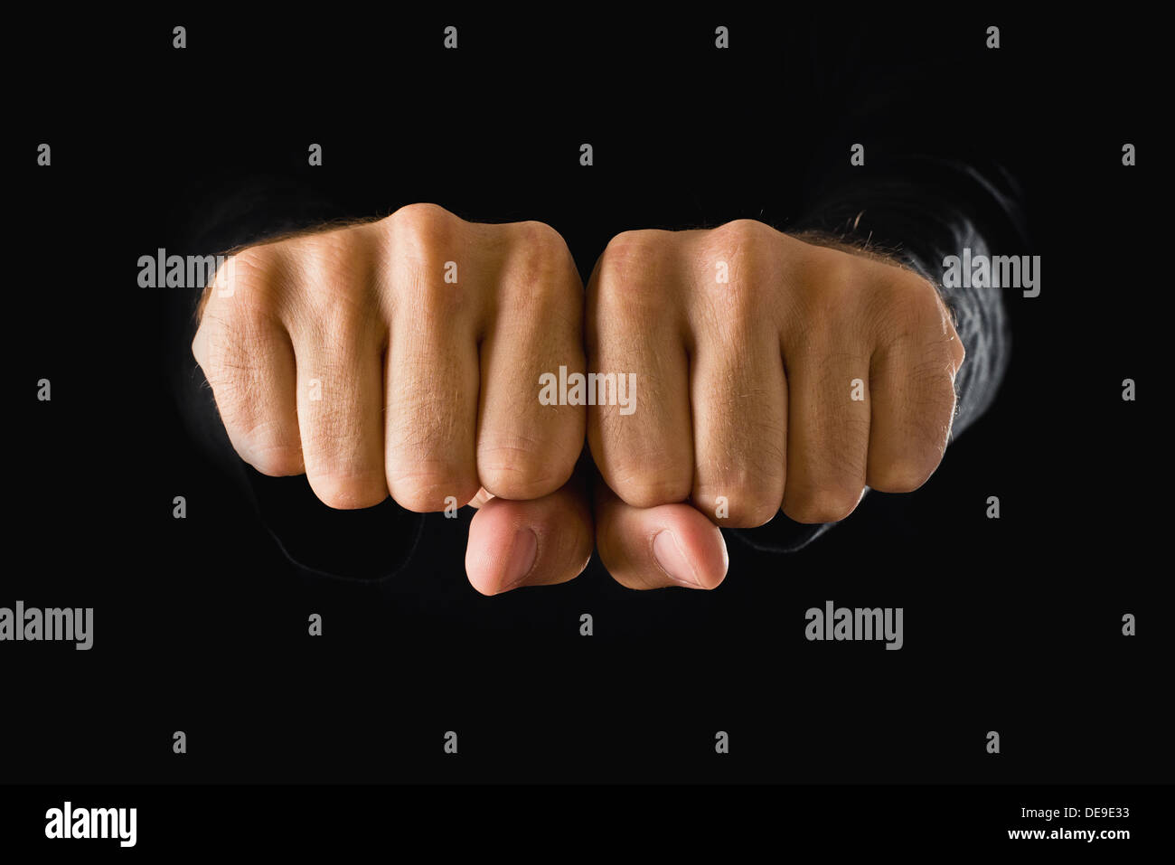 La main avec poing serré sur fond sombre. Puissance, détermination, concept de résistance. Banque D'Images
