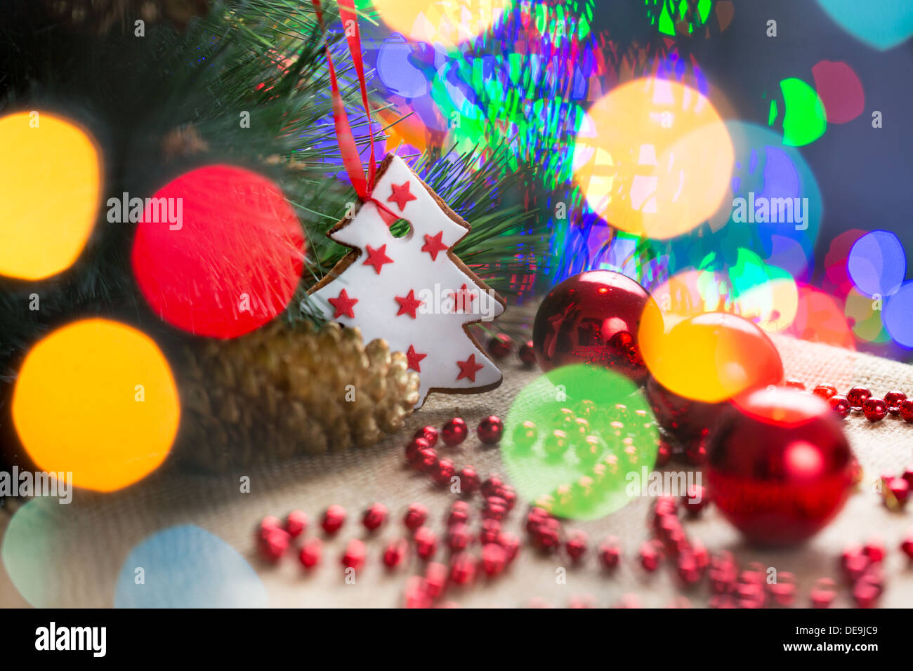 Arbre de Noël avec hochet et gâteau sur fond de fête lumineuse Banque D'Images