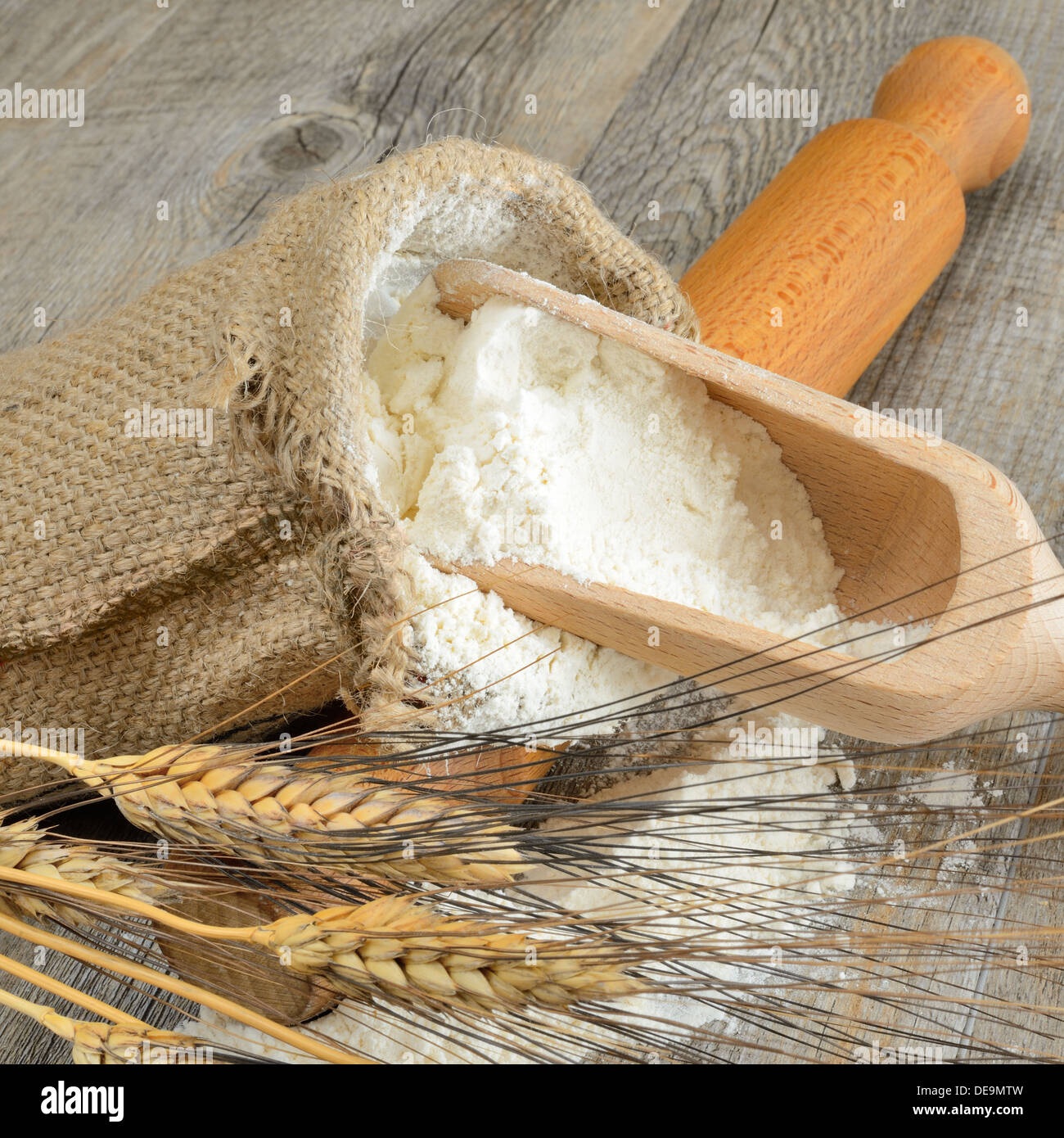 Table en bois avec un sac de farine et une cuillère à oreilles Photo Stock  - Alamy