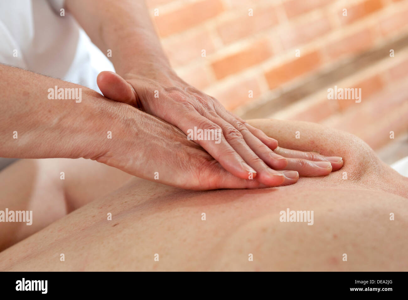 Une paire de mains d'ostéopathes femmes des soins et massage à l'arrière d'une autre femelle Banque D'Images