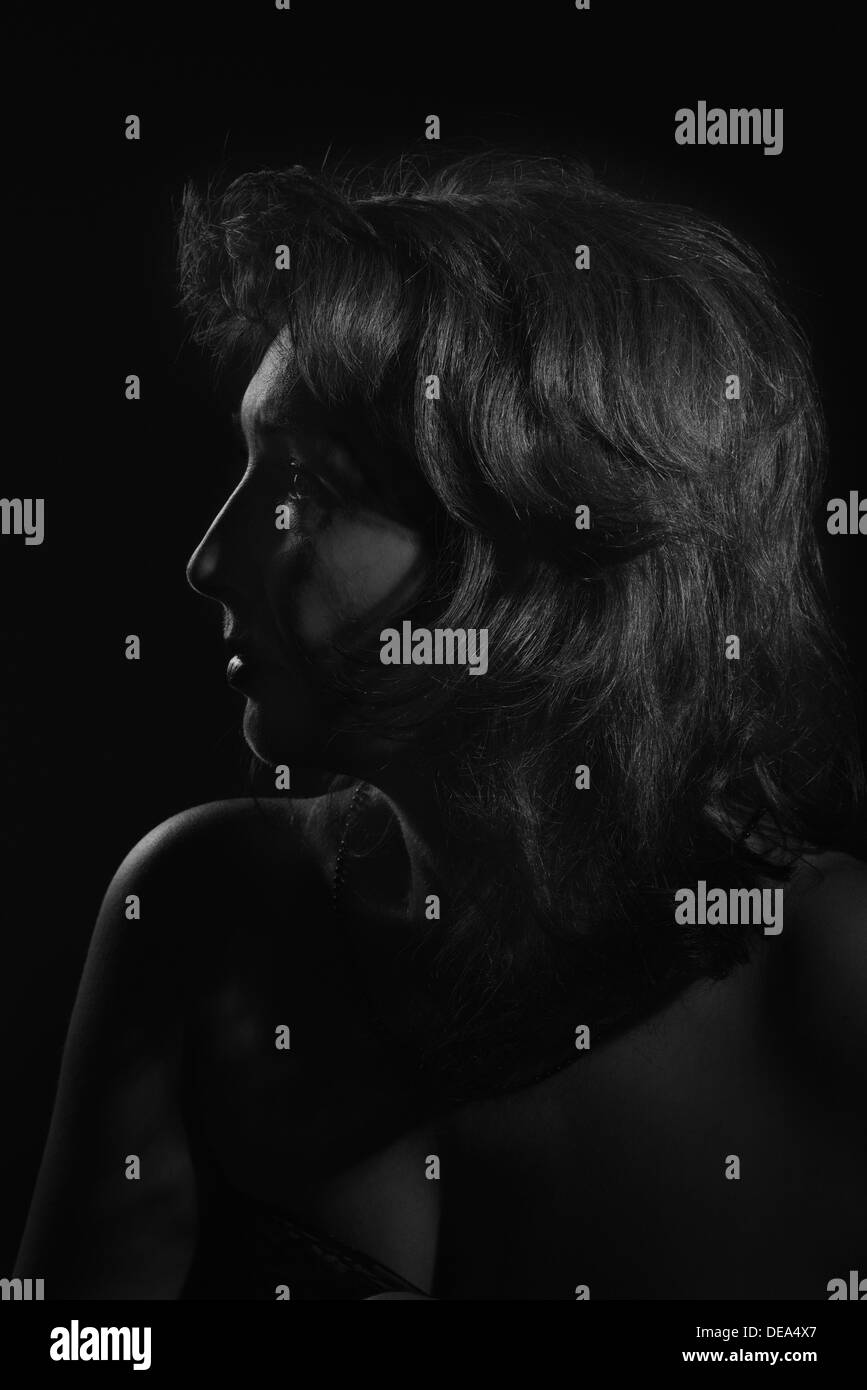 Femme mature avec poils rouges pensive vue latérale sur l’image monochrome  noir Photo Stock