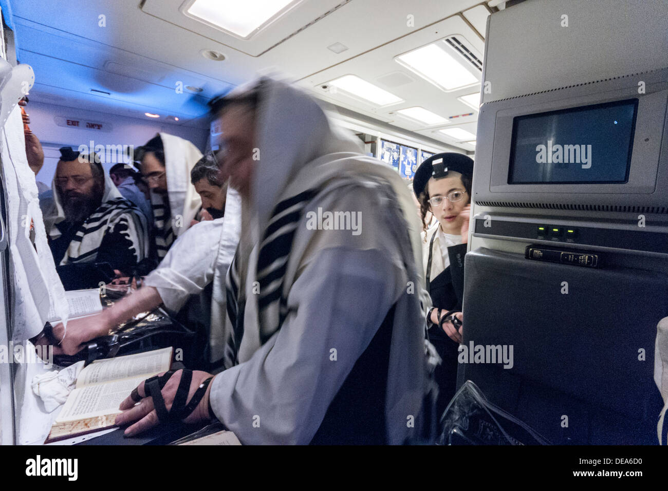 ('Charedi ultra-orthodoxe") Les Juifs avec châles traditionnels prier dans la cuisine d'un avion de ligne Boeing 777 au cours d'un vol. Banque D'Images