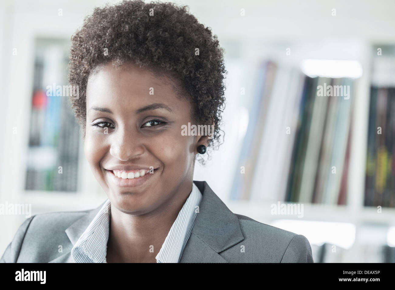 Portrait of smiling young woman avec les cheveux courts à la recherche à l'appareil photo, la tête et épaules Banque D'Images