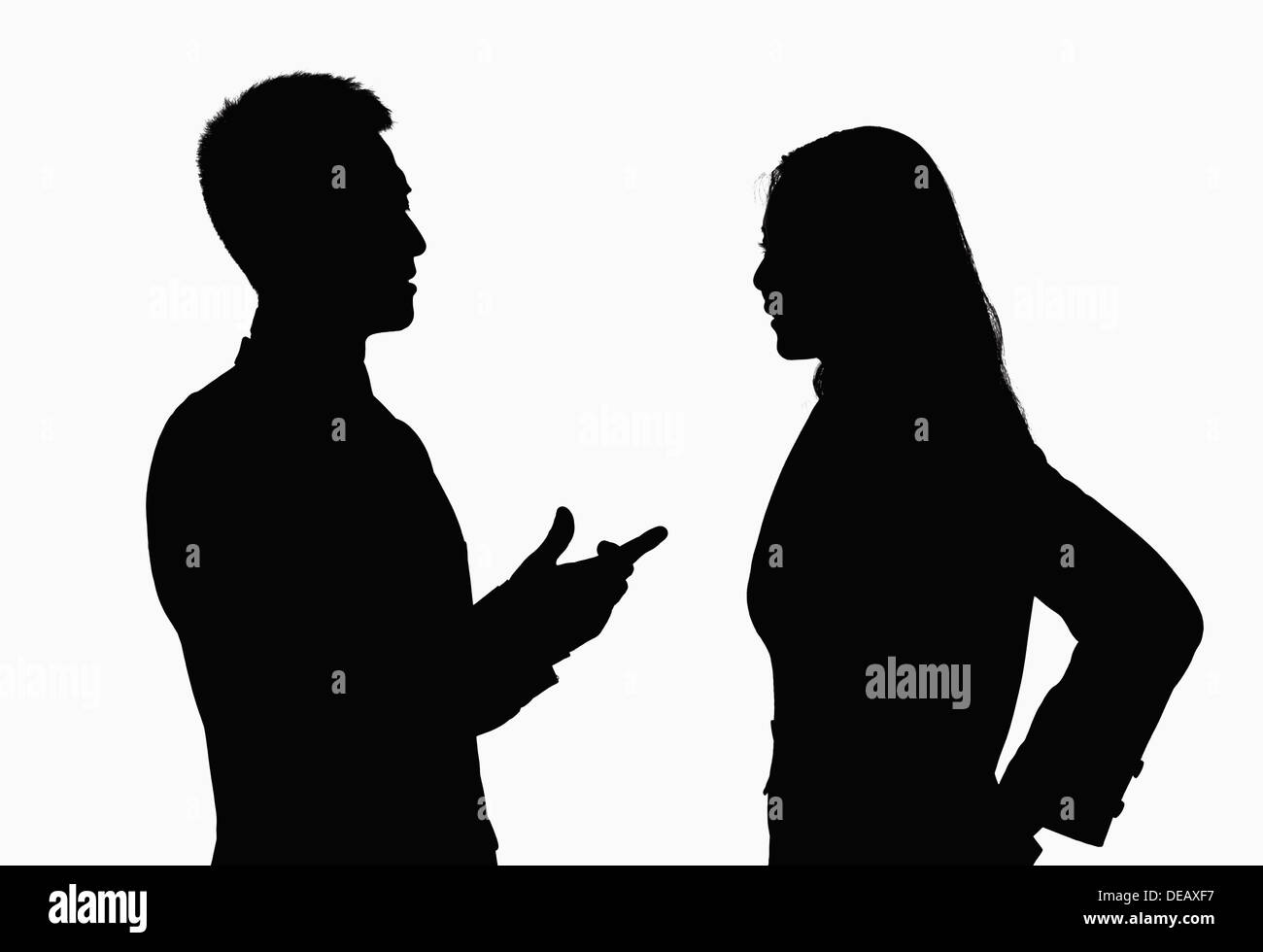 Silhouette of businessman and businesswoman talking. Banque D'Images