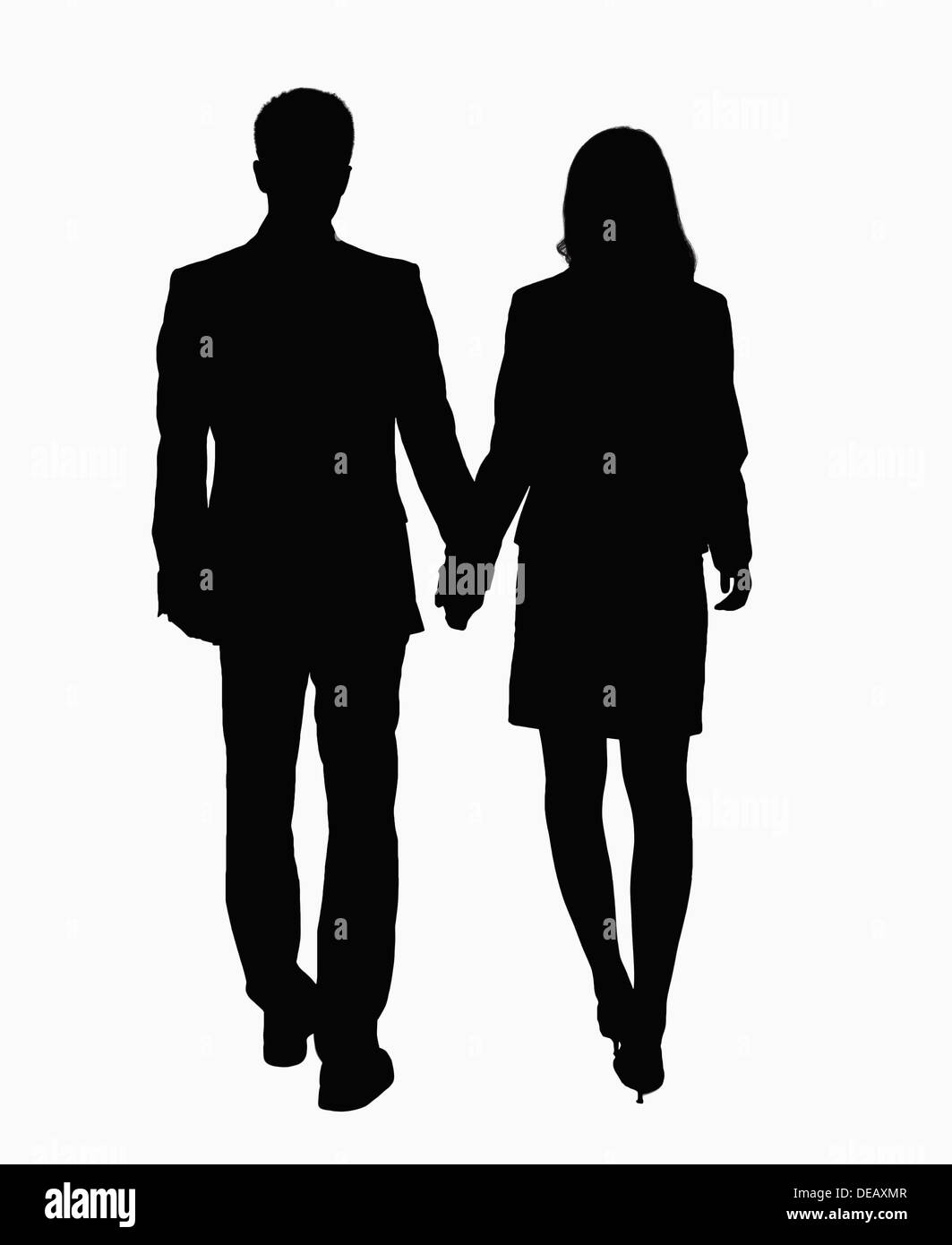 Silhouette of businessman and businesswoman holding hands. Banque D'Images