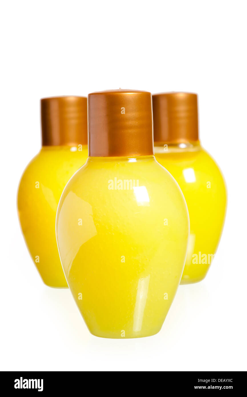 Trois bouteilles de cosmétiques jaune sur fond blanc Banque D'Images