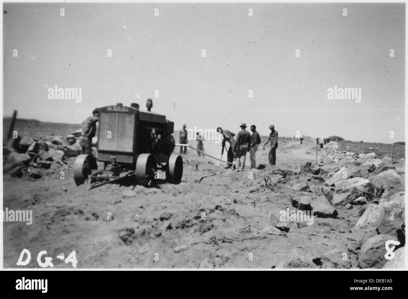 Equipe de marteau-piqueur et de compresseur travaillant sur les pistes de camions, forant de la roche avec un minimum d'explosifs. Banque D'Images