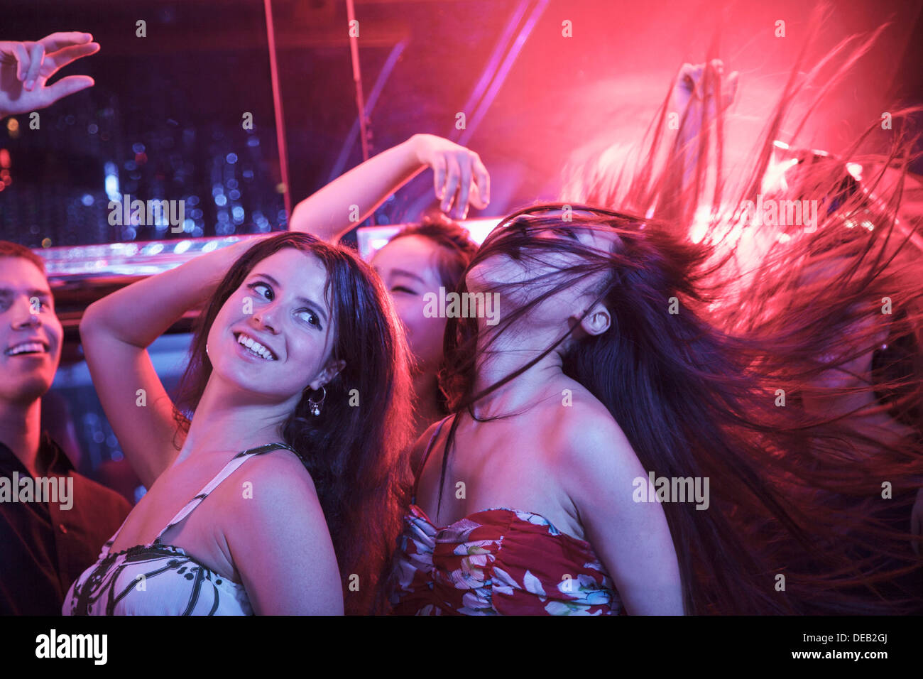 Multi-ethnic group of friends avec les bras en l'air entre la danse des ballons dans une discothèque, d'un sèche mélanger Banque D'Images