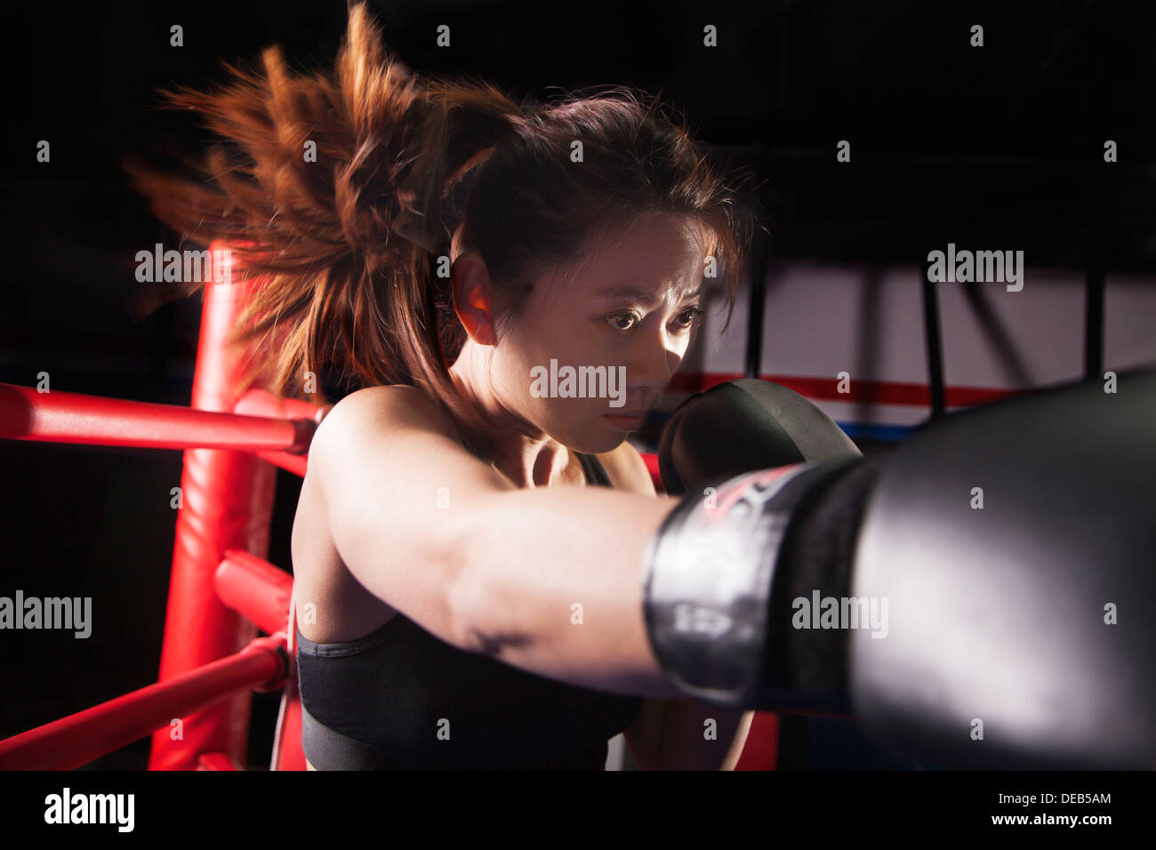 Close up of female boxer jetant d'un poinçon, les cheveux en mouvement Banque D'Images Close up of female boxer jetant d'un poinçon, les cheveux en mouvement Banque D'Images