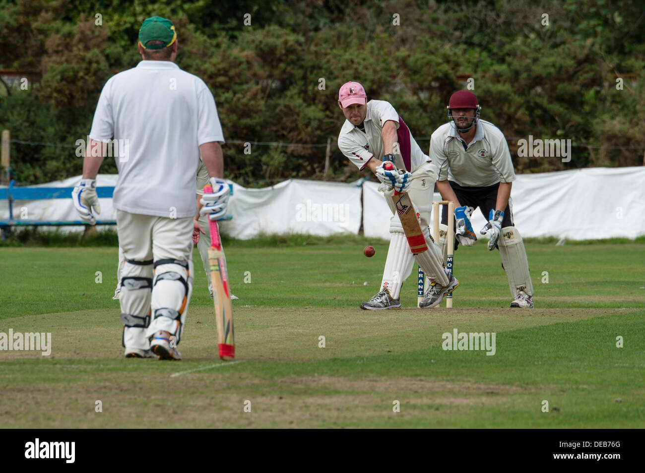Les hommes de jouer un match de cricket village dimanche après-midi, Pays de Galles, Royaume-Uni Banque D'Images