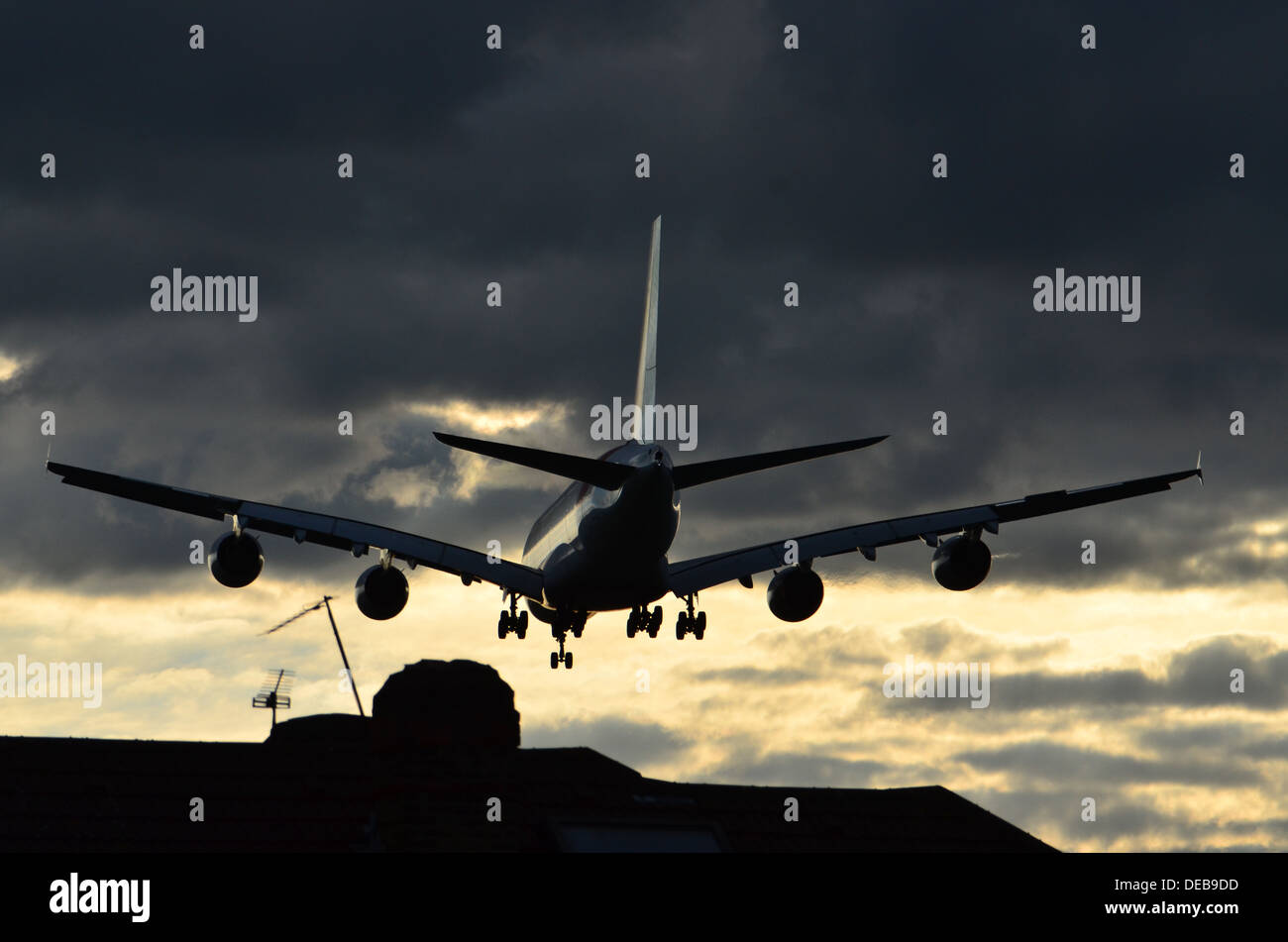 Avion voler bas au-dessus des toits dans une tempête près de l'aéroport d'Heathrow, Royaume-Uni Banque D'Images