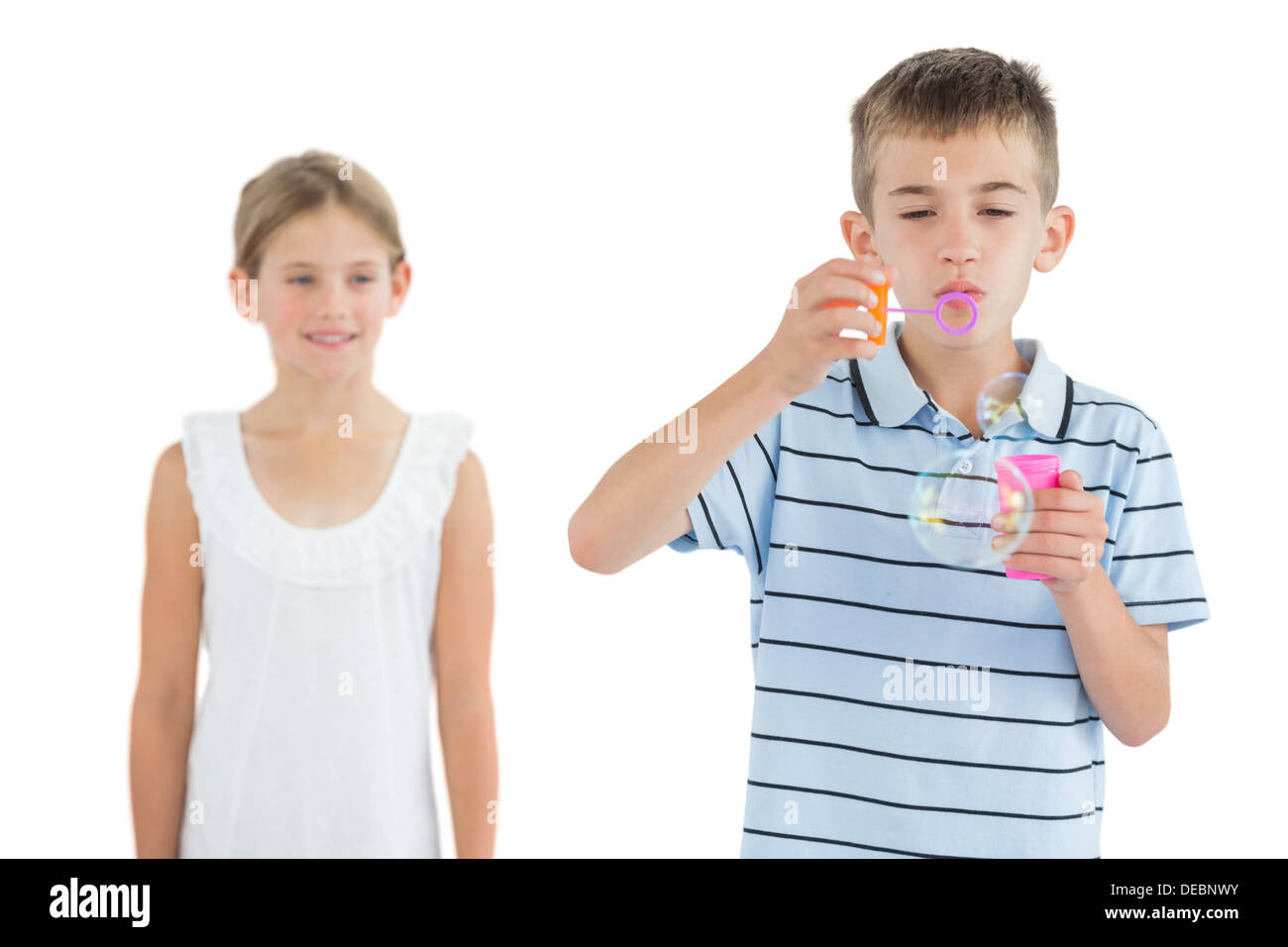 Garçon faire des bulles alors que sa sœur le regarder Banque D'Images