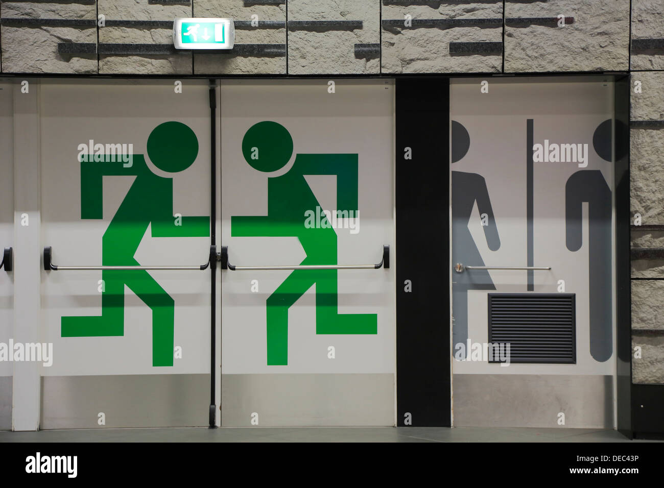 La sortie d'urgence et de toilettes pictogrammes sur les portes de la gare à l'aéroport, Bruxelles, région bruxelloise, Belgique Banque D'Images