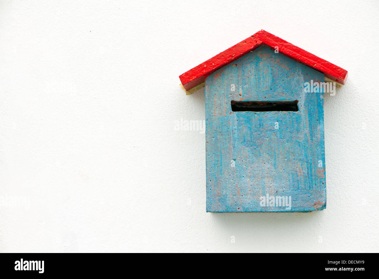 Boîte aux lettres en béton bleu sur mur blanc. Banque D'Images