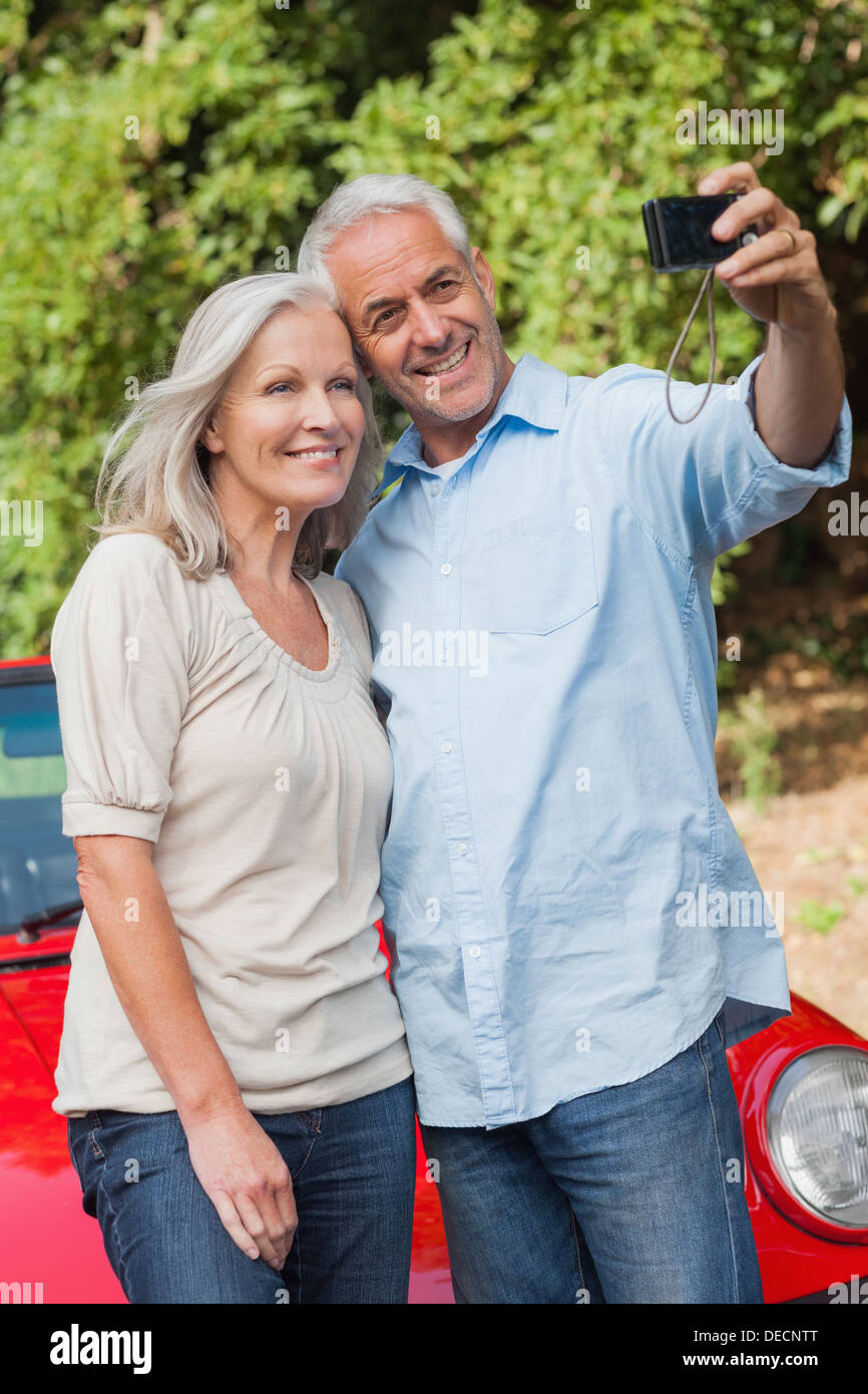 Smiling mature couple prendre des photos d'eux-mêmes Banque D'Images