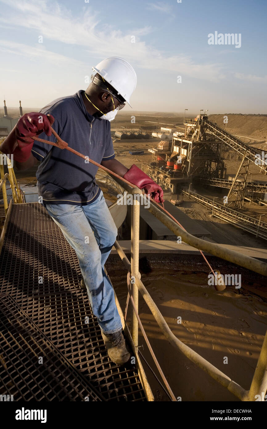 Opérateur de laboratoire, le prélèvement d'un échantillon contenant des boues minérales, de lixiviation au carbone réservoir sur l'usine de traitement de la mine d'or, l'Afrique Banque D'Images
