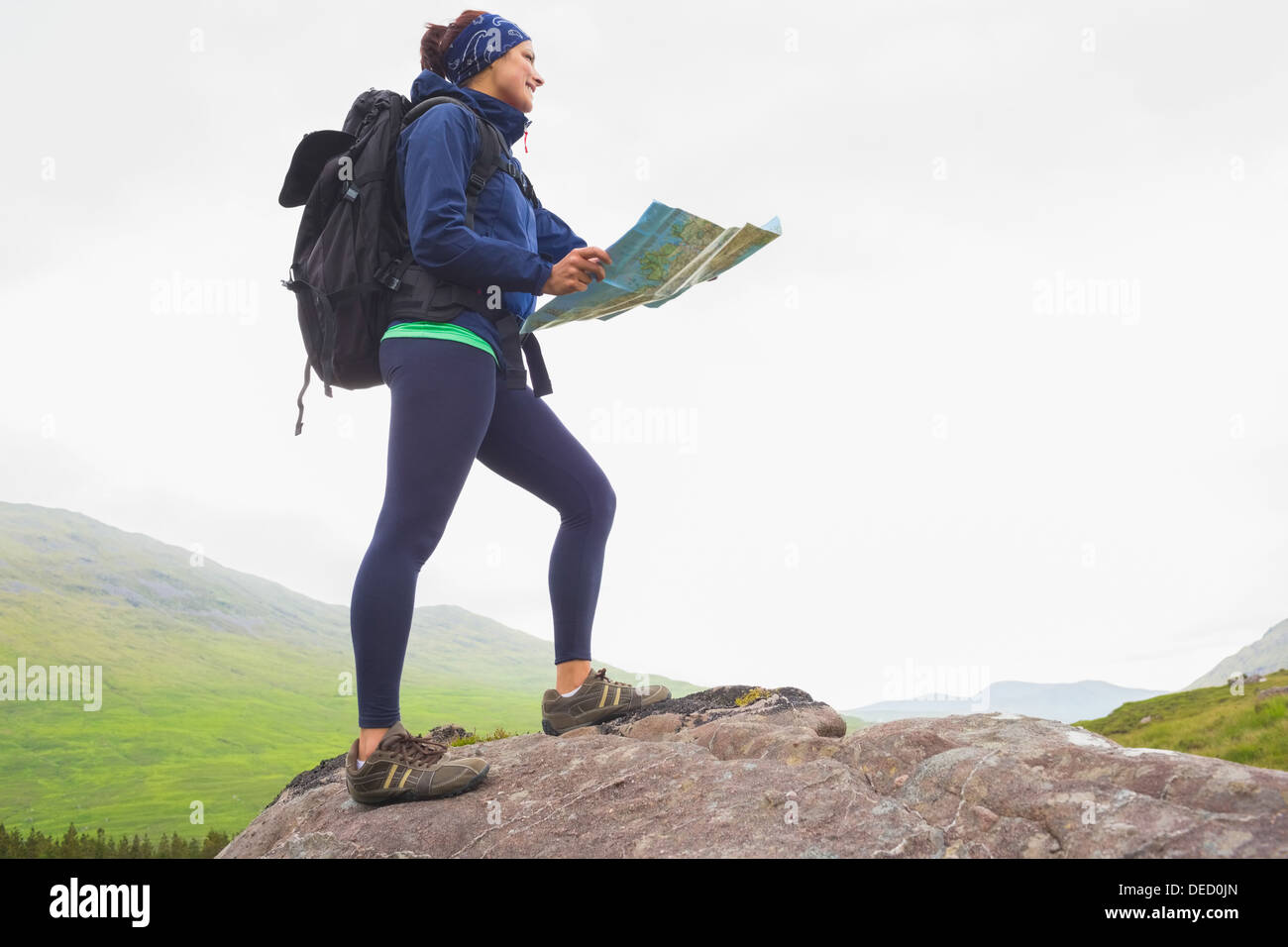 Femme debout sur une roche holding map Banque D'Images