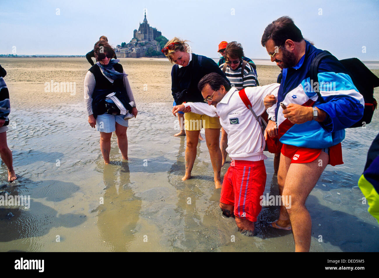 Pèlerins à pied traversée des sables mouvants de la Baie du Mont Saint Michel Manche, Basse-Normandie, Normandie, France, Banque D'Images