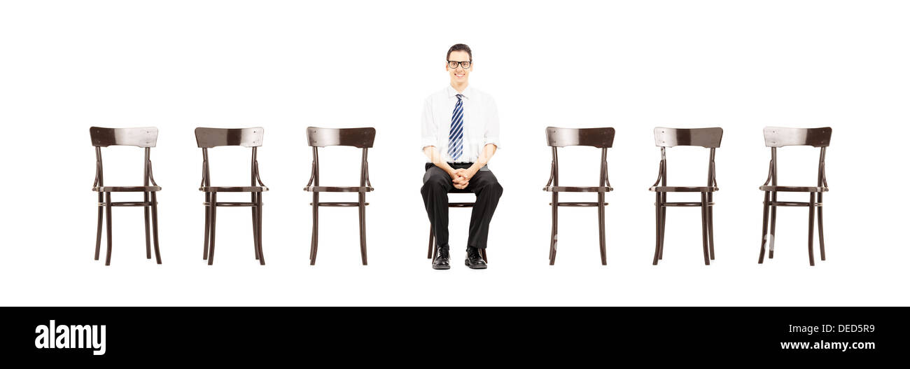 Jeune homme à l'aide d'assis sur une chaise en bois en attente d'entrevue d'emploi Banque D'Images