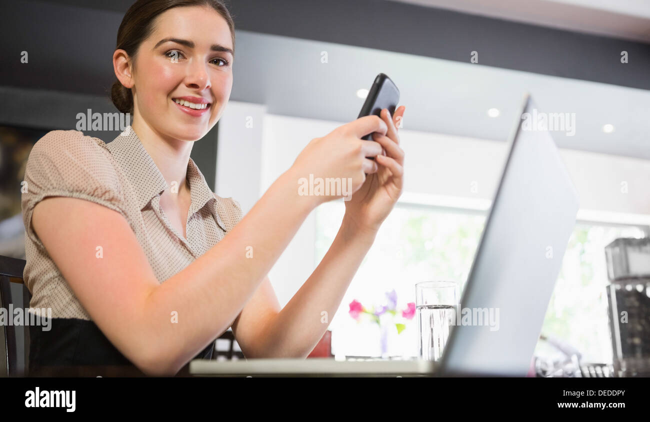 Smiling businesswoman holding phone à Banque D'Images