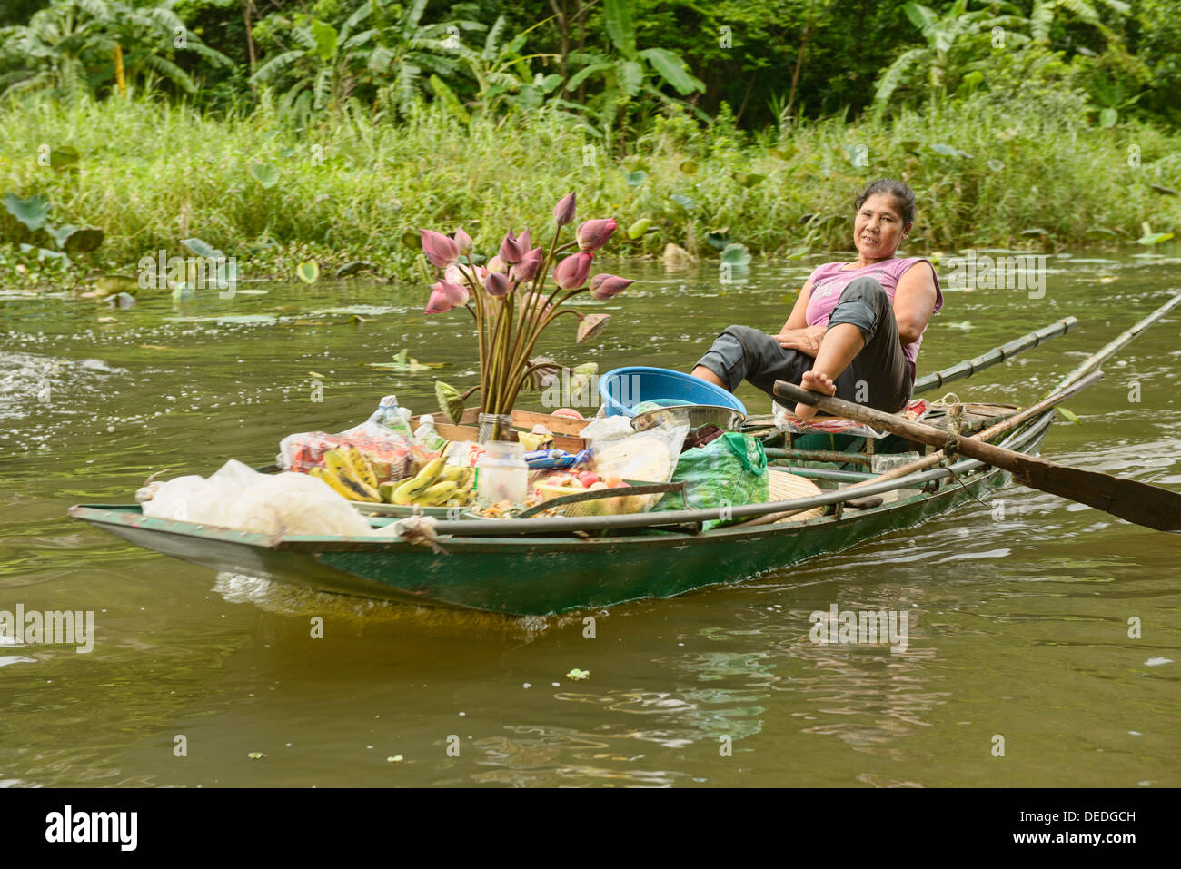 L'aviron du vendeur de lotus avec ses pieds sur la rivière Tam Coc à Ninh Binh, Vietnam Banque D'Images